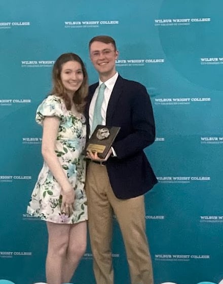 Grant Hauskins holding the Samuel Weingarten Excellence in English Writing Award plaque